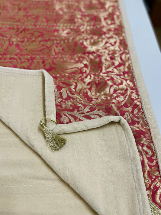 Textile with red and gold pattern and beige border